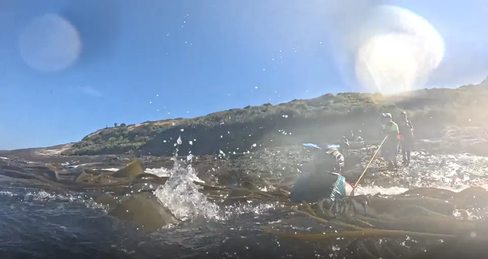 Rocky shoreline seen from water level with spray from the waves