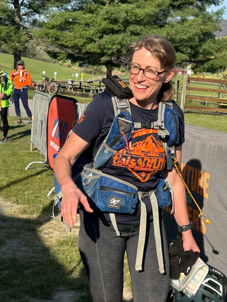 Smiling racer in a Team thisABILITY shirt and race pack at a race venue