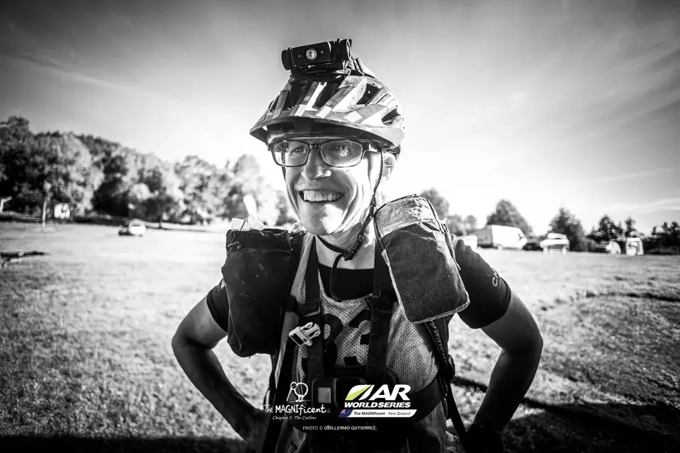 Black-and-white portrait of a smiling racer wearing a bike helmet